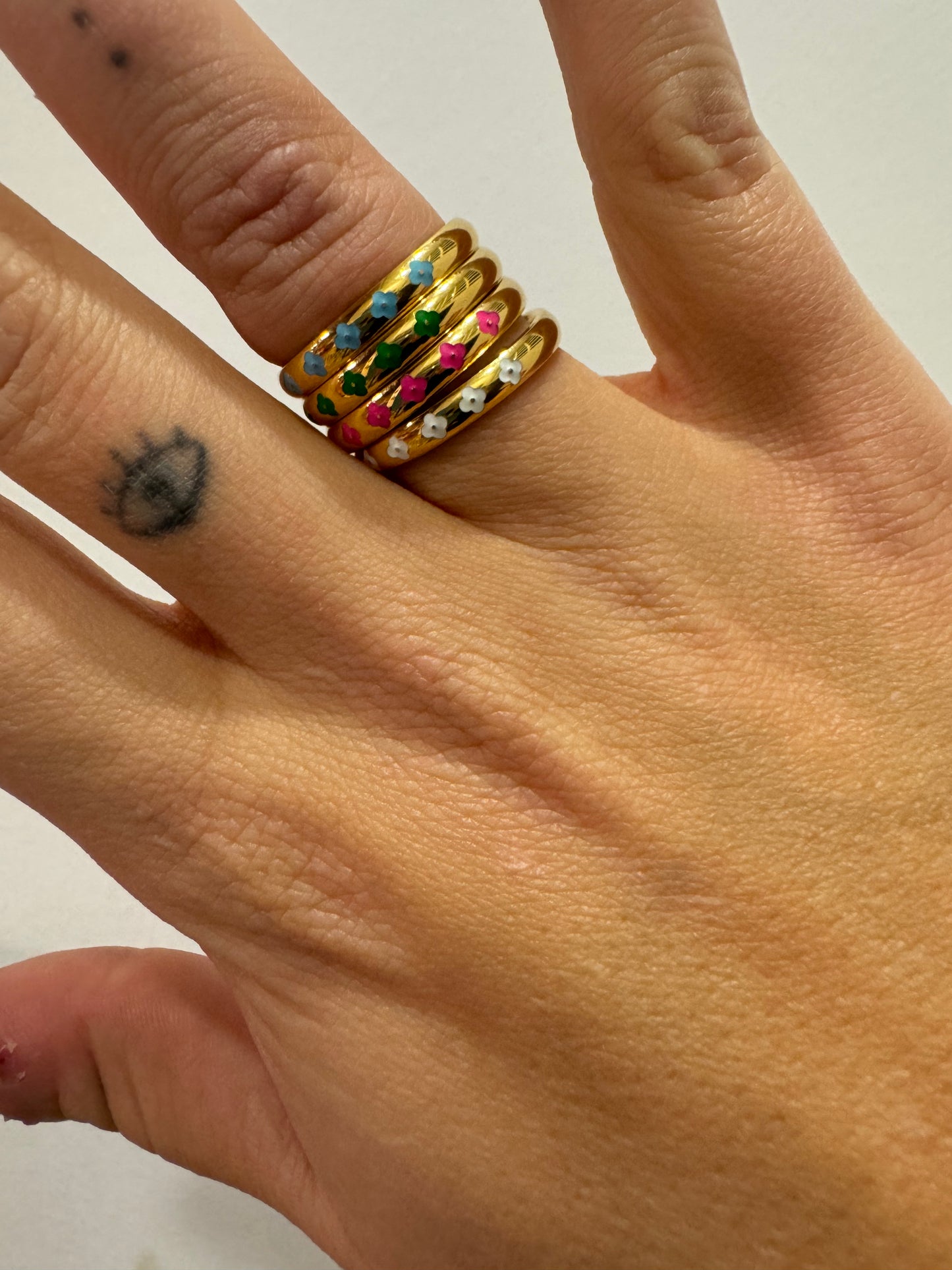 Anillo Dorado con Tira de Cinco Flores Esmaltadas Blanco