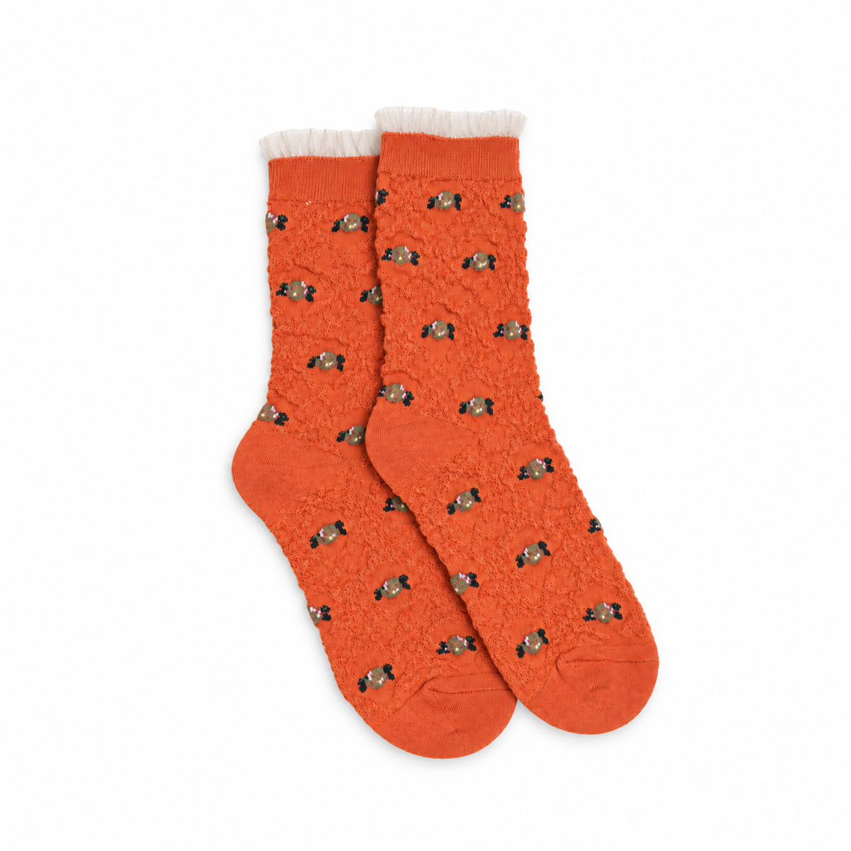 Calcetines coral con flores y volante de tul sobre fondo blanco, vista cenital