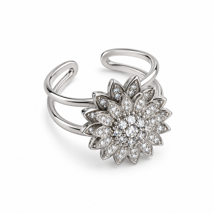 Anillo giratorio plateado con flor de brillantes sobre fondo blanco