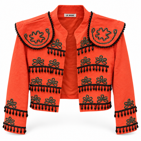 Chaqueta torera naranja con bordados y pedrería sobre fondo blanco