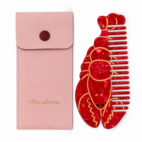 Peine langosta rojo con funda rosa sobre fondo blanco