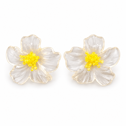 Pendientes flor transparente con estambres amarillos. Foto de estudio sobre fondo blanco.