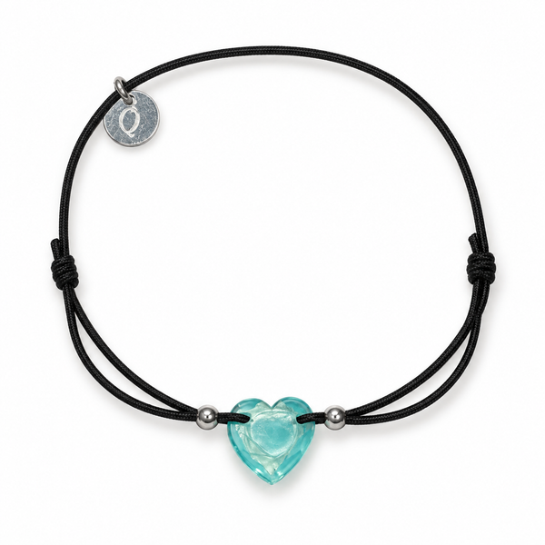 Pulsera negra con corazón turquesa sobre fondo blanco